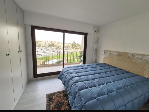 une chambre avec un lit et une grande fenêtre dans l'établissement T2 master, à Mandelieu-la-Napoule