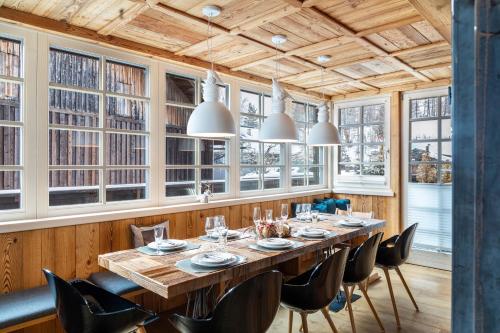 a dining room with a table and chairs and windows at Haus Gabriel - Seefeld in Seefeld in Tirol