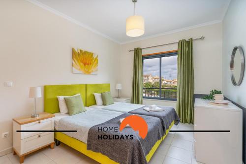 une chambre avec un lit avec un panneau de vacances dessus dans l'établissement #284 Vista das Ondas by Home Holidays, à Olhos de Água