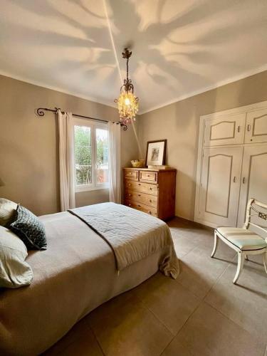 - une chambre avec un lit, une chaise et un lustre dans l'établissement Appartement 6 personnes au coeur d'ALGAJOLA, à Algajola