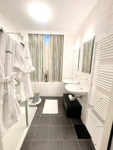 a white bathroom with a sink and a toilet at Luxury City Center apartment with Canal view 1 kingsize bed and 1 sleeping sofa in Amsterdam
