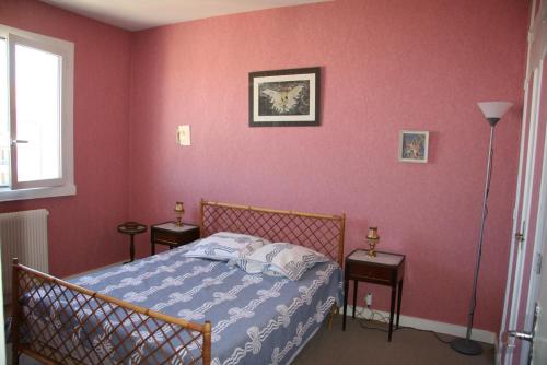 - une chambre avec un lit dans un mur rouge dans l'établissement Appartement Au Sud Avec Vue Bassin, à Arcachon