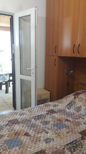 a bedroom with a bed and a sliding glass door at B&B Le Amazzoni in Torre Chianca