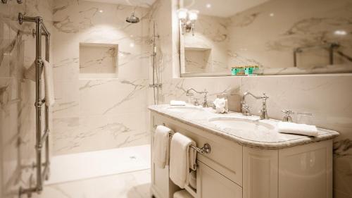 a white bathroom with a sink and a shower at Abbaye De Villeneuve in Les Sorinières