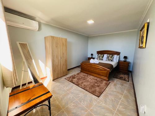 a bedroom with a bed and a wooden cabinet at Noite's House I - Prazeres in Prazeres