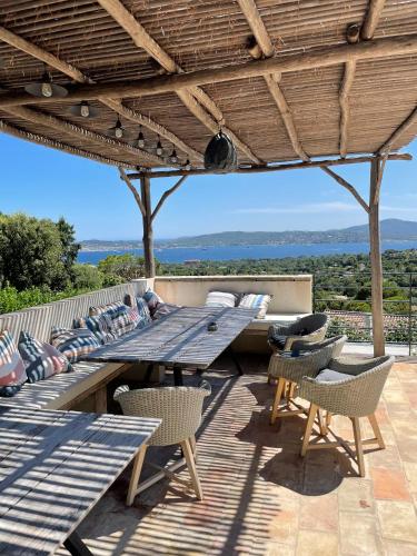 - une table de pique-nique en bois et des chaises sur la terrasse dans l'établissement Villa Les 3 Pins - Spacious Escape with Private Pool and Panoramic Views of the St-Tropez Gulf, à Port Grimaud