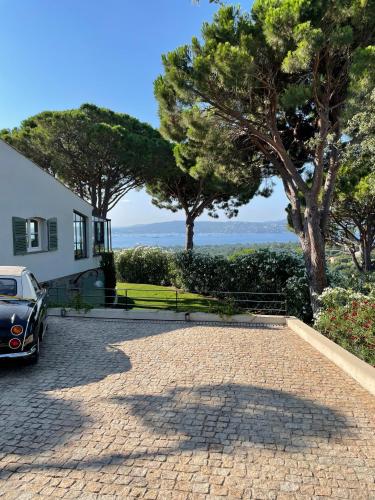 une maison avec une voiture garée dans l'allée dans l'établissement Villa Les 3 Pins - Spacious Escape with Private Pool and Panoramic Views of the St-Tropez Gulf, à Port Grimaud