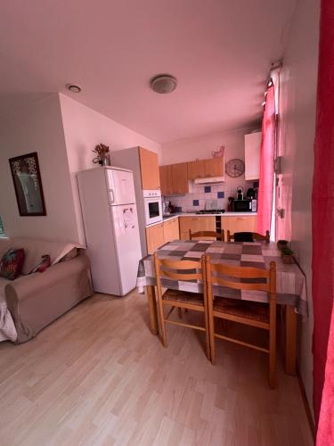 une petite cuisine avec une table et un réfrigérateur dans l'établissement Les Platanes - De Vinci, à Lamalou-les-Bains