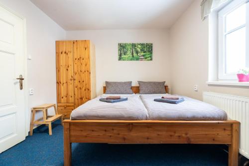 a bedroom with a wooden bed in a room at Penzion Na Výšinkách, Jetřichovice, České Švýcarsko in Jetřichovice