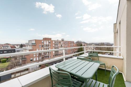 un balcon avec une table et des chaises et une vue dans l'établissement Appartement 2 chambres avec parking et balcon, à Marcq-en-Barœul