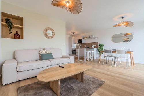 un salon avec un canapé et une table dans l'établissement Appartement 2 chambres avec parking et balcon, à Marcq-en-Barœul