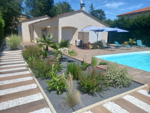 un jardin avec une piscine et une maison dans l'établissement Villa Soleil d'Albi, à Arthès