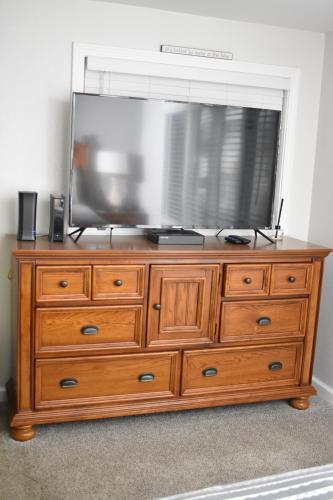 una televisione sopra un comò di legno di Lakefront Home with Amazing Views, Hot tub, Boat JetSki Rental Option a Lake Ozark