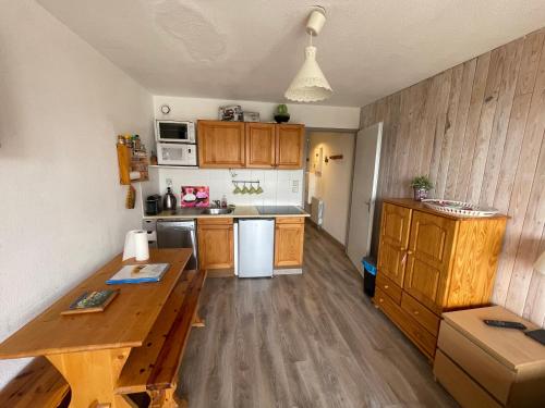 une cuisine avec des armoires en bois et une table en bois dans l'établissement Studio Cabine avec WIFI et vue splendide sur le lac et les montagnes, aux Angles