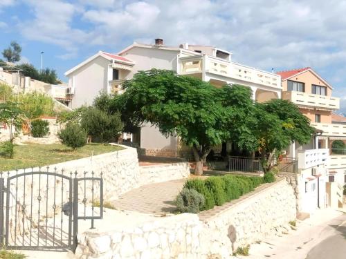ein weißes Haus mit einem Baum davor in der Unterkunft Studio für 6 Personen ca 65 qm in Zubovići, Dalmatien Inseln vor Zadar in Zubovići