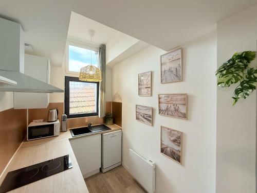 une petite cuisine avec un évier et un micro-ondes dans l'établissement Cosy Corail - 1CH - Place Verdun, à Pau