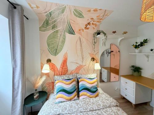 ein Schlafzimmer mit einem Wandbild aus Blättern in der Unterkunft Cosy Corail - T2 - Place Verdun in Pau