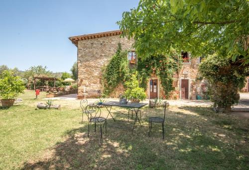 a table and chairs in front of a stone building at Poggio Primo - Bilocale Vermiglio in Castiglion Fibocchi