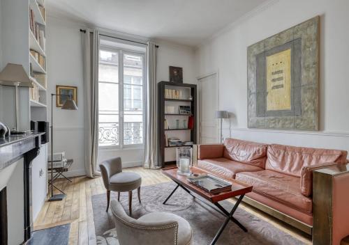 un salon avec un canapé et une table dans l'établissement Spacious Typical Parisian Flat - Paris Le Marais, à Paris