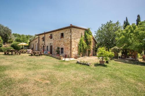 an old stone building in a field with a yard at Poggio Primo - Trilocale Carlotta in Castiglion Fibocchi