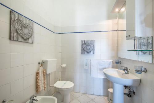 a white bathroom with a sink and a toilet at Poggio Primo - Trilocale Carlotta in Castiglion Fibocchi