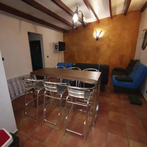 a dining room with a table and chairs and a couch at Appartement moderne au Moule avec terrasse et jardin in Le Moule