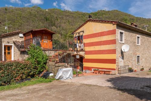a building with red and yellow stripes on it at Agriturismo Il Ponte - Frantoio in Vicchio