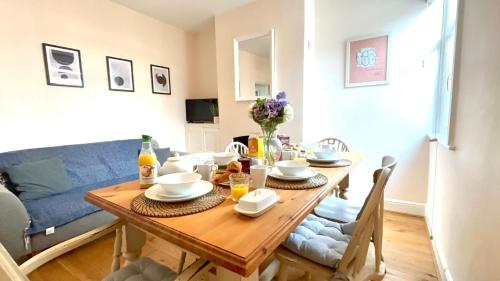 a dining room with a table and a blue couch at Seascape Luxury Cottage Southwold - Free Parking in Reydon