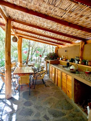 a kitchen with a table and chairs and a wooden ceiling at Cabañas El Albaricoque Cochiguaz in El Sanjeado