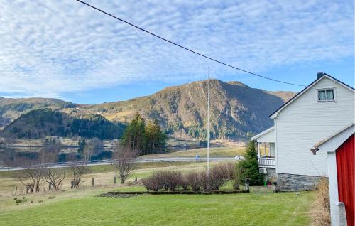 a white house with a mountain in the background at Gorgeous Home In Åheim in Åheim