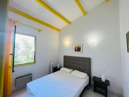 une petite chambre avec un lit et une fenêtre dans l'établissement Appartement 2 pièces 4 couchages LUMIO, à Lumio