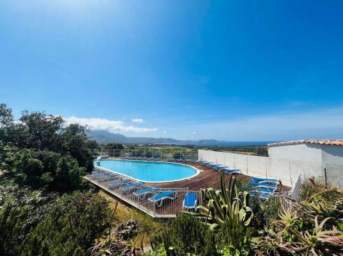 une piscine avec des chaises longues et l'océan dans l'établissement Appartement 2 pièces 4 couchages LUMIO, à Lumio