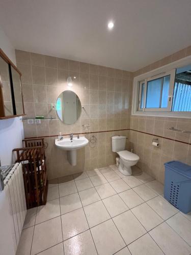 une salle de bain avec un lavabo, des toilettes et un miroir dans l'établissement Anglet Chiberta - Proche plage et golf, à Anglet