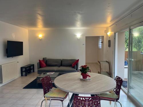 a living room with a table and a couch at Anglet Chiberta - Proche plage et golf in Anglet