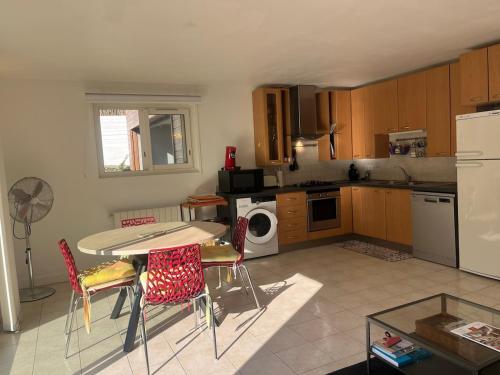 a kitchen with a table and chairs in it at Anglet Chiberta - Proche plage et golf in Anglet