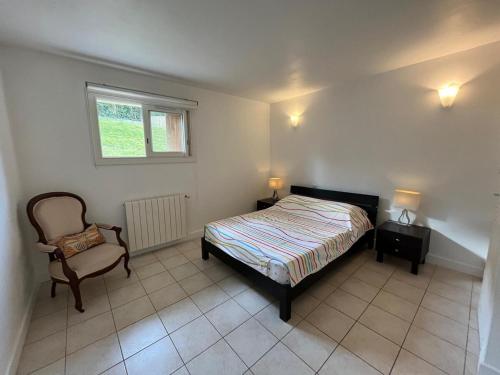une chambre avec un lit, une chaise et une fenêtre dans l'établissement Anglet Chiberta - Proche plage et golf, à Anglet