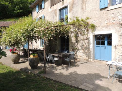 a patio with a table and chairs and a building at Nabat le Haut, chambre et table d'hotes in Courniou