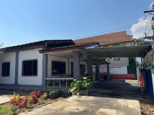 a large white house with a roof at Baboo Guesthouse in Chiang Dao