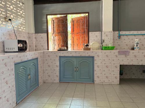 a kitchen with blue doors and pink tiles at Baboo Guesthouse in Chiang Dao