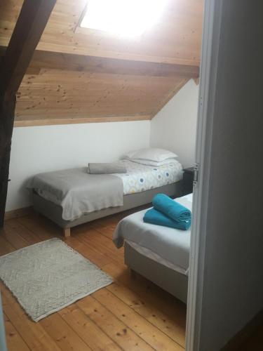 two beds in a room with a wooden ceiling at Gîte au Bon Accueil Therence in Sainte-Thérence