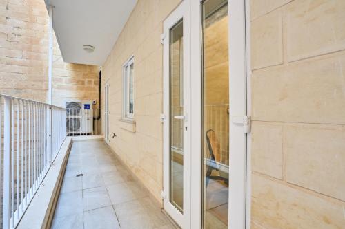 a hallway with a glass door and a balcony at Modern Two Bedroom Apartment in Valletta in Valletta