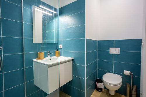 une salle de bain bleue avec des toilettes et un lavabo dans l'établissement Chez Yvette 1 Ground floor Near the sea, à Leucate