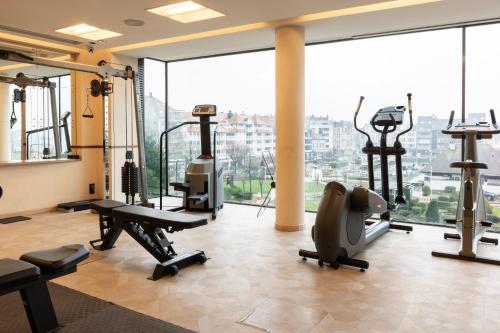 a gym with exercise equipment and a large window at Hotel Beach Palace by CW Hotel Collection in Blankenberge