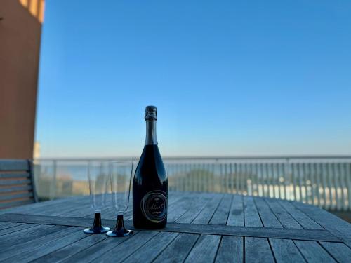 a bottle of wine sitting on a table on a beach at 82, Attico Leonardo in Lido Adriano