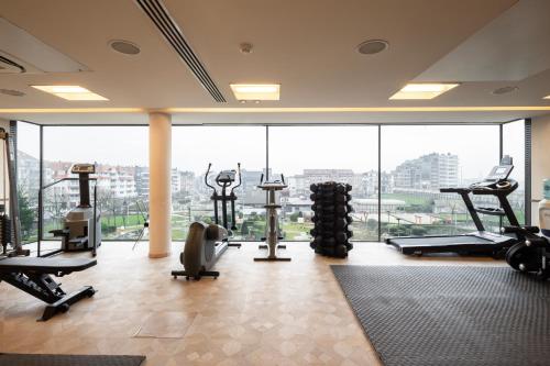 a gym with treadmills and machines in a building at Hotel Beach Palace by CW Hotel Collection in Blankenberge