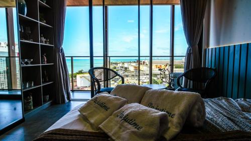 Una sala de estar con un sofá y una ventana grande. en New Time Paju 1110, en Maceió