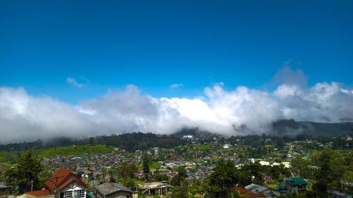 a city on a hill with clouds in the sky at The Mount Lodge in Nuwara Eliya