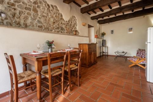 a kitchen and dining room with a wooden table and chairs at Ginestra in Arcidosso