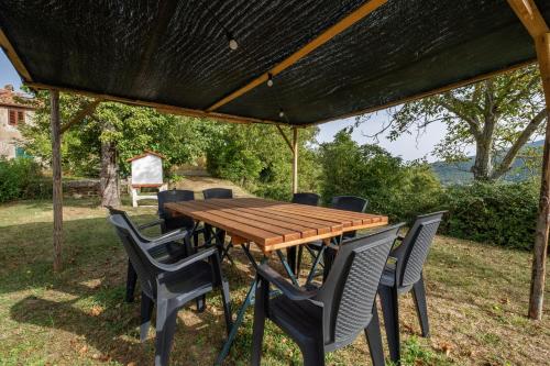 a wooden table and chairs under a pergola at Pianperugino in Arcidosso