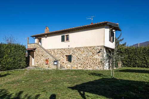 an old stone house with a yard in front of it at Pianperugino in Arcidosso